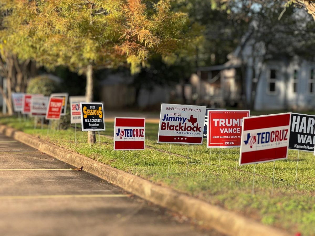 Candidate signs displayed on the property across from a polling place on election day.